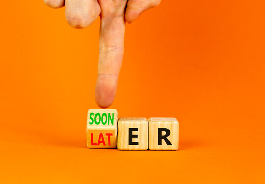 Sooner or later symbol. Businessman turns wooden cubes and changes the word Later to Sooner. Beautiful orange table orange background. Copy space. Business and sooner or later concept.