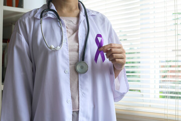 Woman doctor in white uniform hold purple ribbon on hand. 