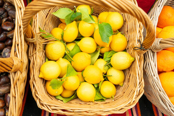 Ripe yellow lemons in a basket are sold at a street market. Vitamins, diet, organic farm products
