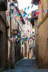 Vista de una típica calle de un pueblo español durante las fiestas con los banderines adornando.