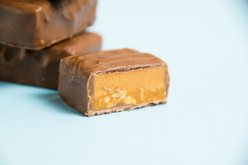 Delicious chocolate bars with salted caramel on a blue paper background