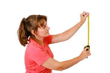 A young woman measures the wall in the house, isolated on a white background. Measurements during repair in a new apartment.