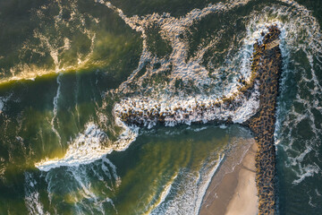 Fototapeta na wymiar Waves crashing on a jetty along the coastline