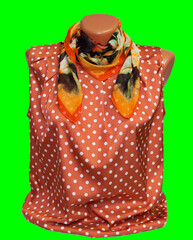 Women's silk scarf on a mannequin and pink jacket with white polka dots. shawl. On an isolated...