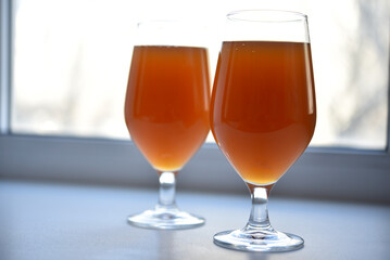 Beer glass on a white background. Beer on the windowsill.