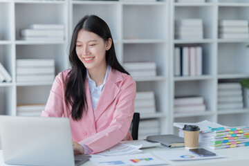 Shot of a beautiful young financial assistant sitting in front of laptop and fill the form in the office.