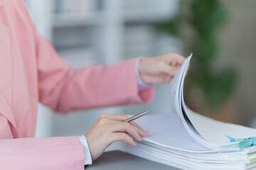 Sharing good business news. Attractive young businesswoman talking on the mobile phone and smiling while sitting at her working place in office and looking at laptop PC.
