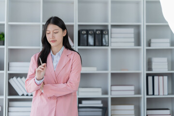 Sharing good business news. Attractive young businesswoman talking on the mobile phone and smiling while sitting at her working place in office and looking at laptop PC.