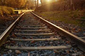 railroad tracks, metal rails, concrete sleepers in sunlight, engineered structures with guide rail...