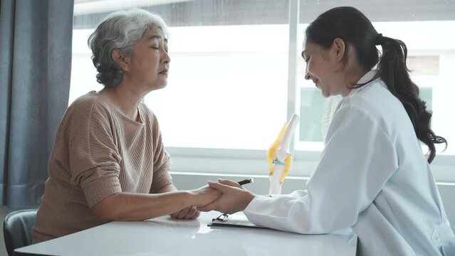 Senior asian chinese woman takes a doctor osteoporosis doctor give help take care of mature handicapped grandmother