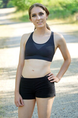 Attractive sporty young woman posing in sportswear on a sunny summer day in nature	