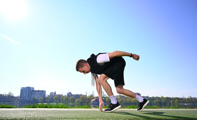 A young man stands by the lake in the morning, warm up, stretch and train near the serene lake, ready for a run.