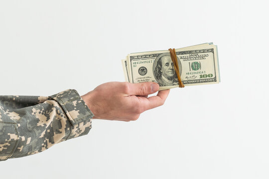 Army soldier holding money against white background