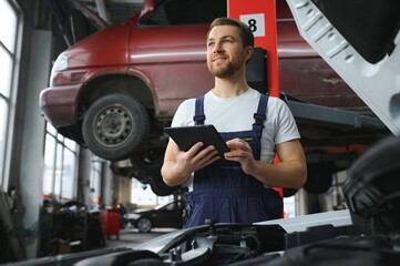 Automobile computer diagnosis. Car mechanic repairer looks for engine failure on diagnostics...