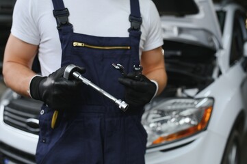 Hand with wrench. Auto mechanic in car repair .