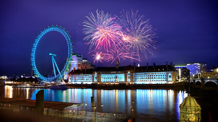 Fireworks sparkling in London sky next to river Thames and famous Ferris wheel. Festivity in the...