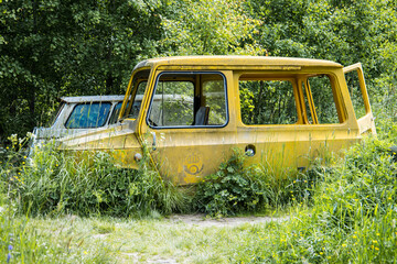 Goteborg, Sweden, 21 June, 2022: Abandoned car of the swedish post rotten in a forest
