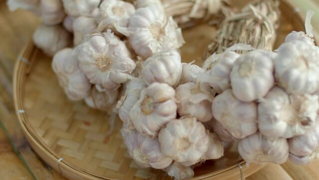 Garlic clove or garlic bulb on wooden background.The garlic in a basket close-up.