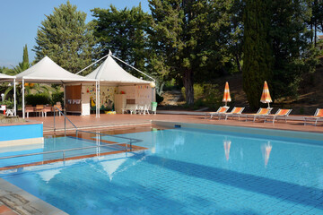Large resort pool with beach umbrellas, sun loungers and lounge chairs