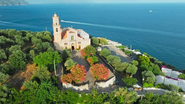 Aerial top view of a sunset over a Church with a bell ringing in a rural area. Chiesa San Pancrazio Martire - a Catholic colourful Church in Conca dei Marini on Amalfi Coast, Italy, Europe in ProRes 4
