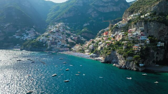 Aerial drone view of colourful Positano cliffside village on Amalfi Coast, Italy. Top view of a well-known holiday destination with beachfront and narrow streets in the Mediterranean Sea, Europe.