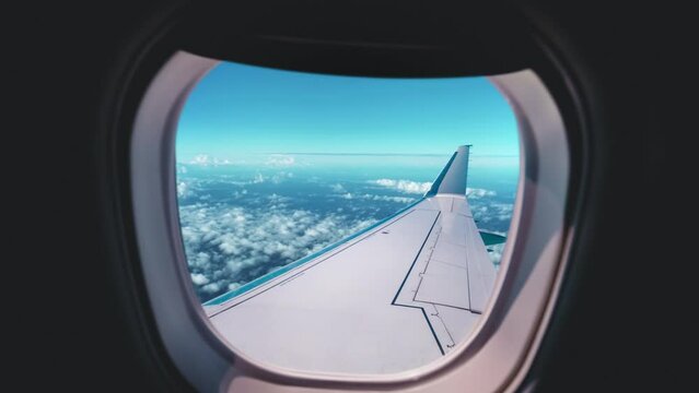 Beautiful view of cloud and wing of airplane from window with a nice blue sky