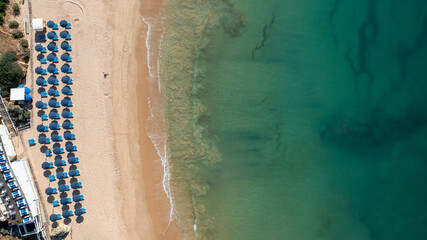 Straight down aerial photo of the beautiful town in Albufeira in Portugal showing the Praia de Albufeira beach with and people relaxing on vacation on the beach on a hot summers day in the summer time