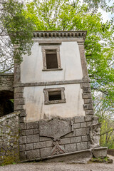 Fototapeta na wymiar The ancient leaning house inside the park of monsters in Bomarzo, Italy