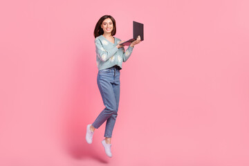 Full body cadre photo of jumping optimistic young woman using laptop freelance copywriter work...