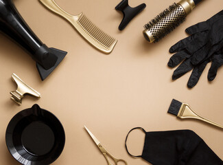 Hairdressing tools on a beige background. Frame of objects hair salon , scissors, gloves, mask, scissors, combs, hair dryer. Centered space for text