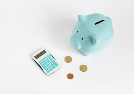 Illustration of counting money. Blue piggy bank with calculator and coins on white background - Powered by Adobe