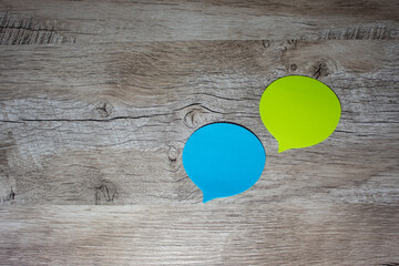 Thoughts in the Form of a Colored Paper Sticker. Speech Bubbles on a Light Wooden Background.