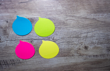 Thoughts in the Form of a Colored Paper Sticker. Speech Bubbles on a Light Wooden Background.