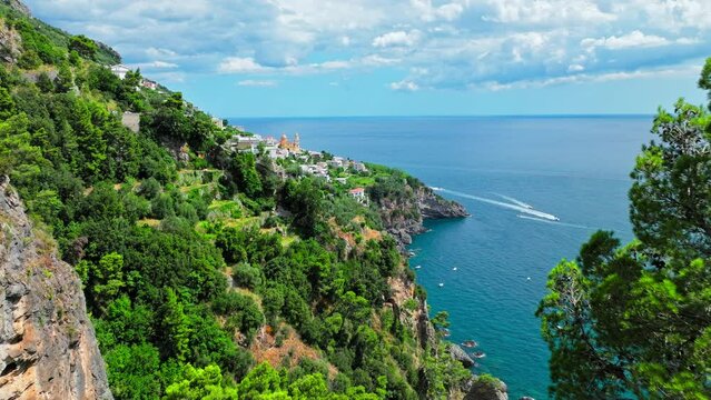 Mediterranean rocky cliffs with caves in Praiano, Italy with transparent water. Aerial drone view of green Amalfi Coast with crystal clear sea and turquoise waters in Europe in ProRes 4K.