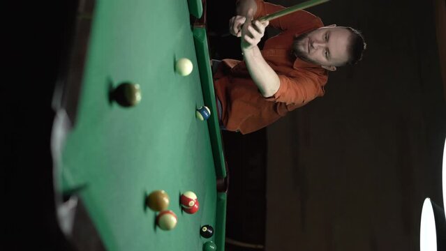young successful handsome man playing in american pool at bar alone. Copy space