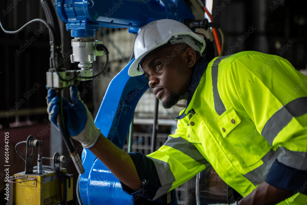 Leinwandbilder engineer working with robot arm automated welding machine in modern metal factory.