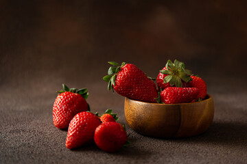 Fresh red strawberries on dark brown background