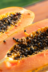 Two pieces of papaya on windowsill on a hot sunny day. Papaya cut in half.
