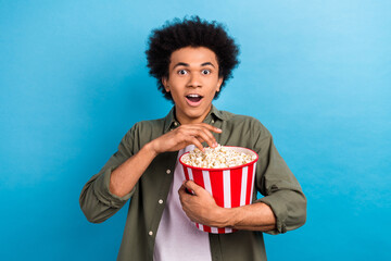 Photo of shocked man funny chevelure hold bucket crispy eat popcorn snacks unexpected movie action...