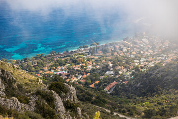 Eze-Bord-de-Mer, ses villas et sa plage à travers les nuages bas depuis le sommet du Mont Bastide