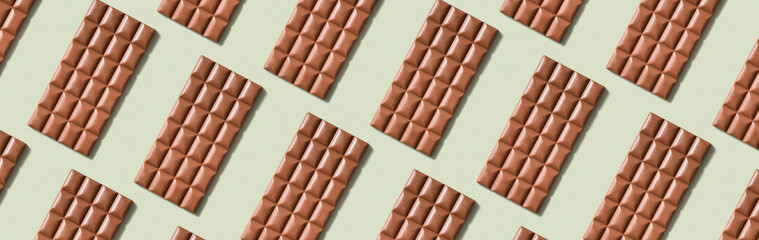 Chocolate bar pattern flat lay, top view on pastel green background