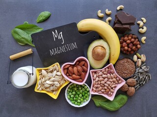 Magnesium rich foods. Natural food sources of magnesium. Assortment of fresh fruit, vegetable, nuts and seeds high in magnesium. Banana, nuts, seeds, beans, avocado, milk, dark chocolate, spinach, etc