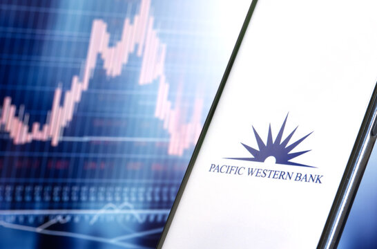 Pacific Western Bank, Pacwest Bancorp logo on smarfone screen, stock chart in the background, USA May 11, 2023