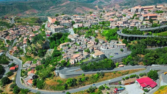 Aerial view of a serpentine road with an Italian old town in the background. Gerace old village in Calabria region in Italy.