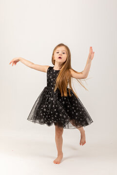 Portrait of cute smiling little girl in black princess fluffy dress.