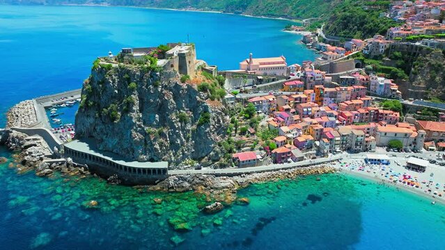 Aerial view of touristic blue lagoon beach with people relaxing in Calabria. Drone view of a beach with an incredibly blue sea in the south of Italy on a summer sunny day.