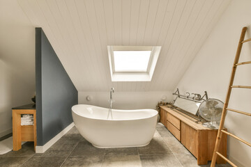 Fototapeta na wymiar a bathroom with a skylight above the bathtub and wooden ladders on the wall next to the tub