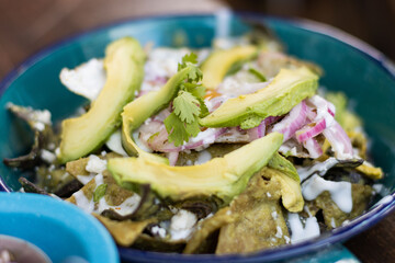 CHILAQUILES CON HUEVO AGUACATE Y TORTILLA MORADA 