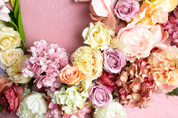 A bouquet of flowers is in a vase with a pink background.