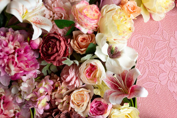 A bouquet of flowers is in a vase with a pink background.
